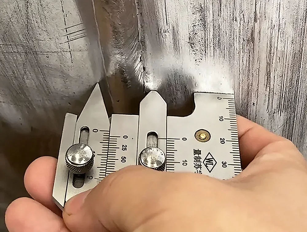 Field inspection photo of using hi-lo weld gauge to measure misalignment value on metal weld joint