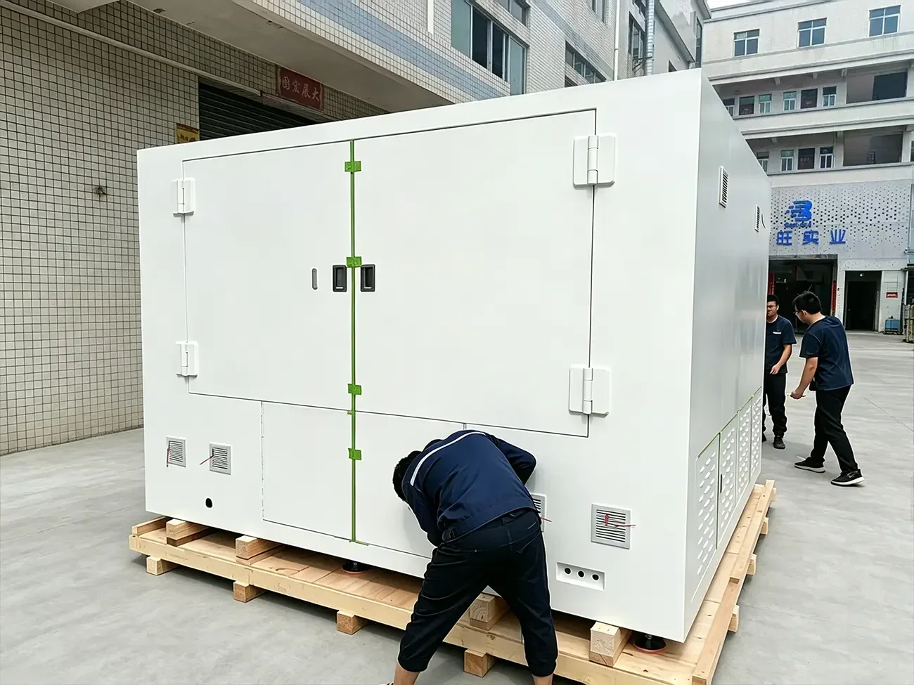 Workers assemble large industrial X-ray CT radiation shielding enclosure in factory workshop